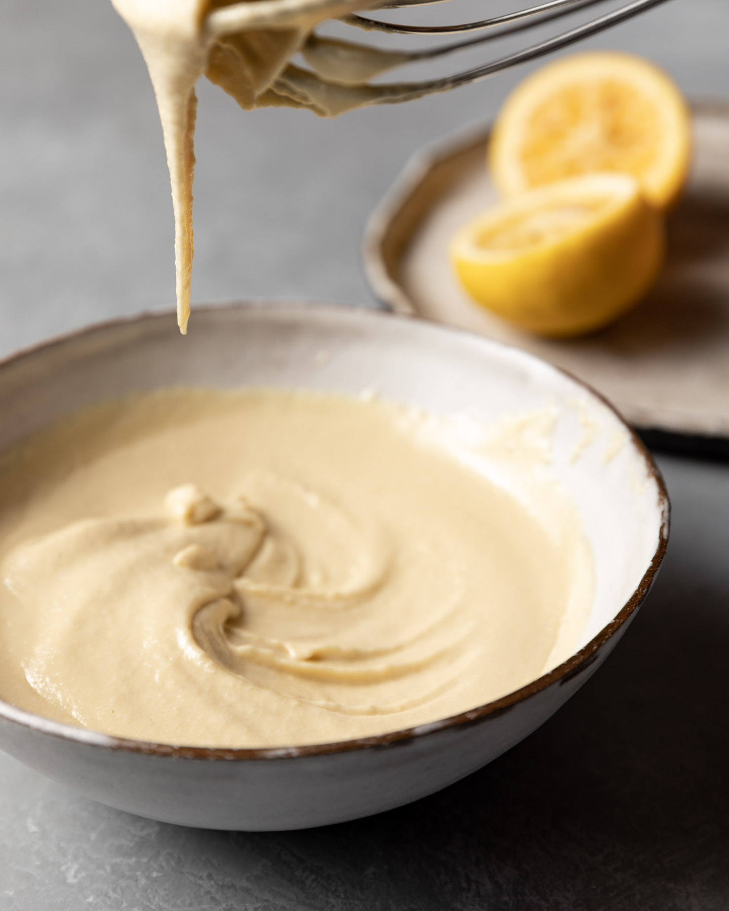 Tahini, lemon juice, and olive oil are whisked together to create a dressing for the cabbage.