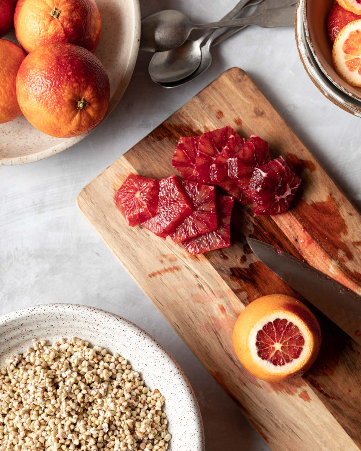 Vibrant blood oranges are peeled and sliced before being placed on top of buckwheat breakfast bowls.