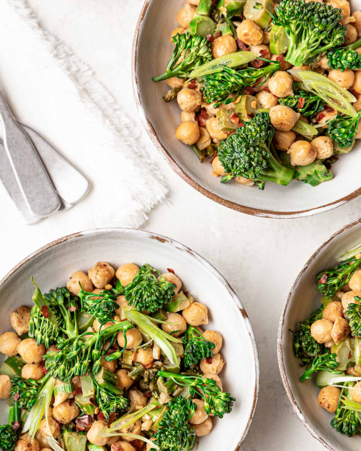 An overhead view of three bowls filled with the finished stir fry